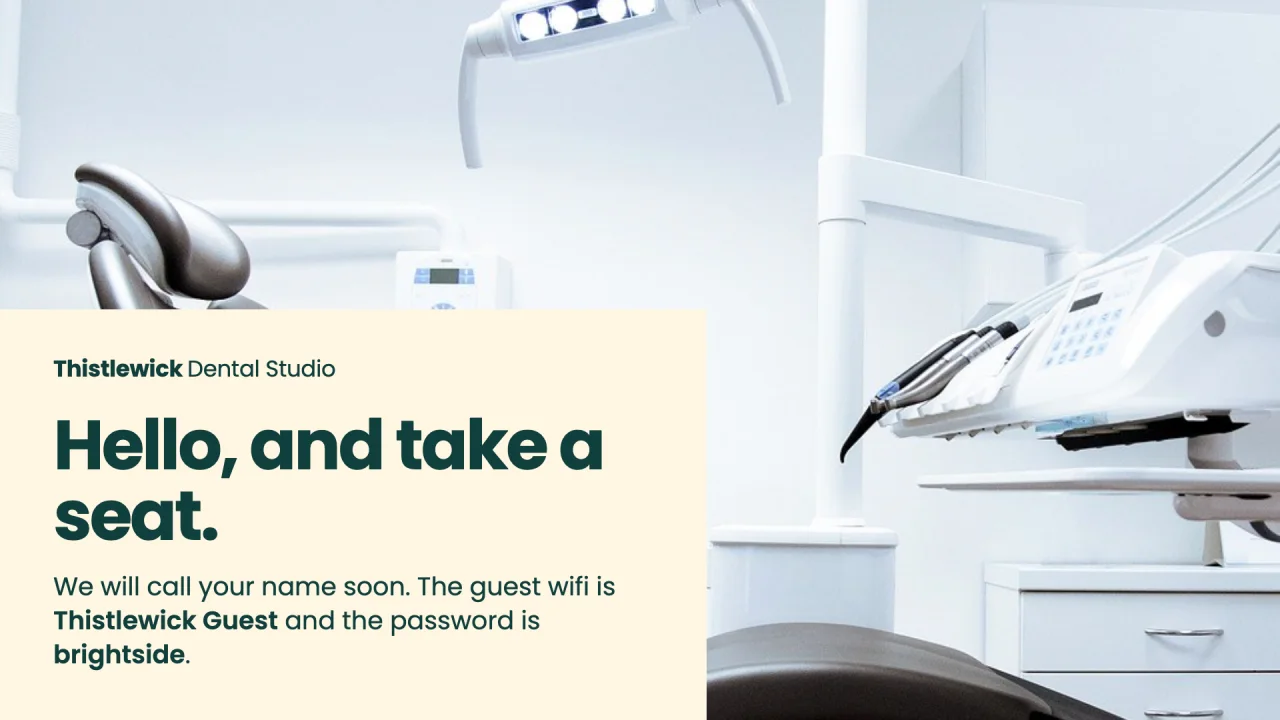 Example slide for Thistlewick Dental Studio. An empty dental chair in a bright room, with the words hello, and take a seat and the guest wifi details.